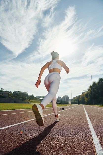 Mujer joven activa en ropa deportiva está haciendo ejercicio al aire libre