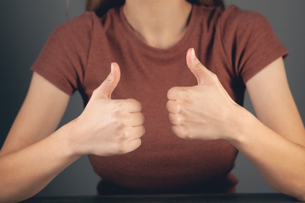 mujer joven, actuación, pulgares arriba