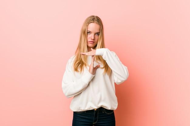 Mujer joven adolescente rubia mostrando un gesto de tiempo de espera.