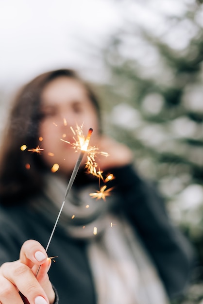 Mujer joven adulta con estrellitas en el bosque de pinos de invierno