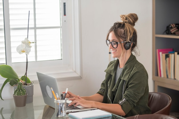 Mujer joven adulta feliz en conferencia de video llamada en casa en estilo de vida de trabajo de oficina alternativa libre de trabajo inteligente
