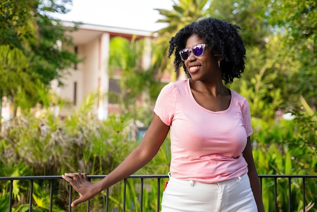 Mujer joven afroamericana posando con gafas de sol