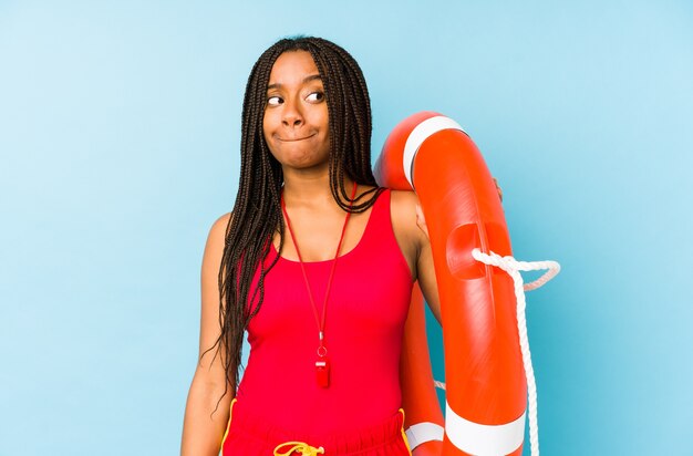 Mujer joven afroamericana salvavidas aislada confundida, se siente dudosa e insegura.