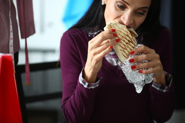 Mujer joven agita con avidez delicioso shawarma. Concepto de receta de Shawarma