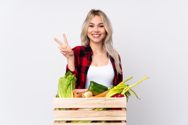 Mujer joven agricultor sobre pared aislada