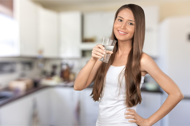 Foto mujer joven, agua potable, en, fondo borroso