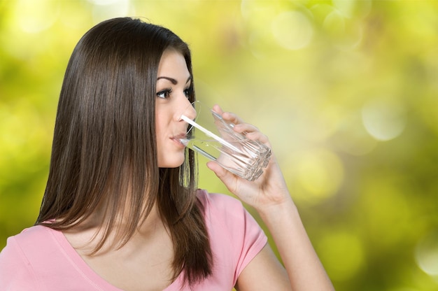 mujer joven, agua potable, en, fondo borroso