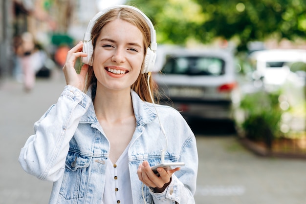 mujer joven, aire libre, escuchar música, en, auriculares