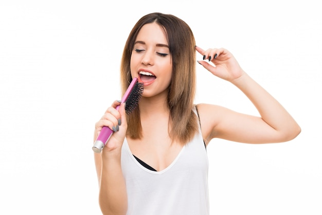 Mujer joven aislada blanca con peine del pelo