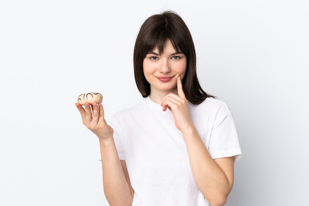 Mujer joven aislada en blanco sosteniendo una rosquilla