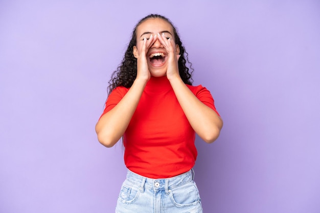 Mujer joven aislada en fondo púrpura gritando y anunciando algo