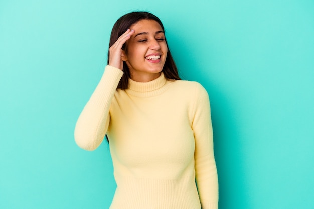 Mujer joven aislada en la pared azul alegre riendo mucho