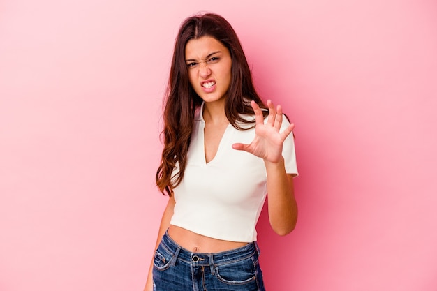 Foto mujer joven aislada en la pared rosada mostrando garras imitando a un gato, gesto agresivo