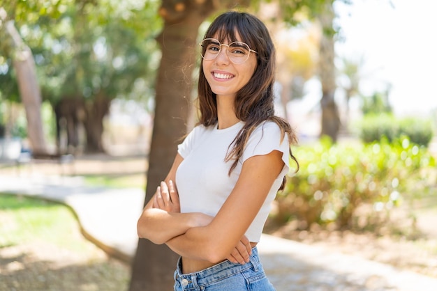 Mujer joven al aire libre con los brazos cruzados y mirando hacia adelante