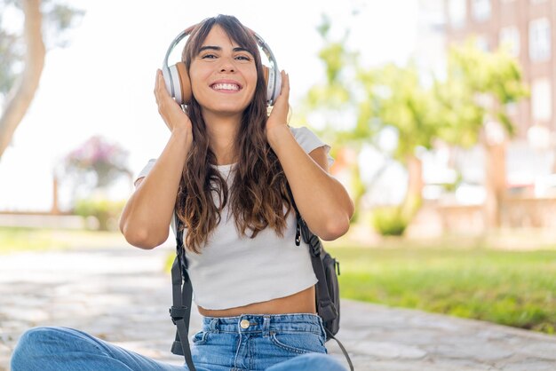 Foto mujer joven al aire libre escuchando música