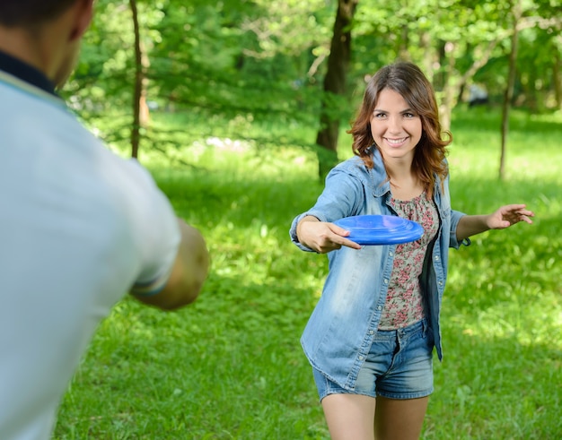 Mujer joven al aire libre lanzando un frisbee en el parque