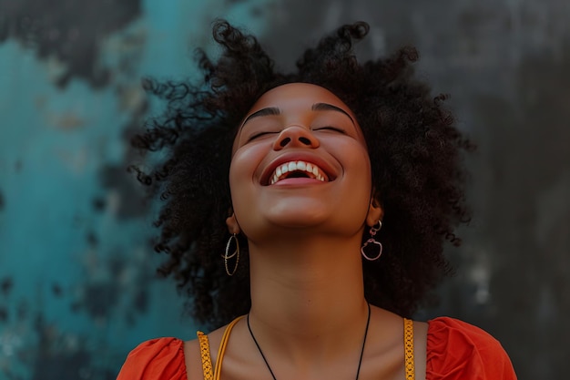 Mujer joven alegre con el cabello rizado riendo contra un fondo azul texturizado que representa la felicidad y la positividad