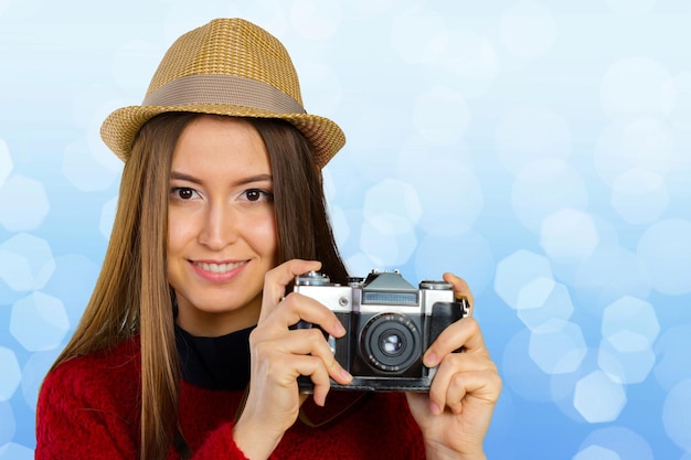 Mujer joven alegre con cámara