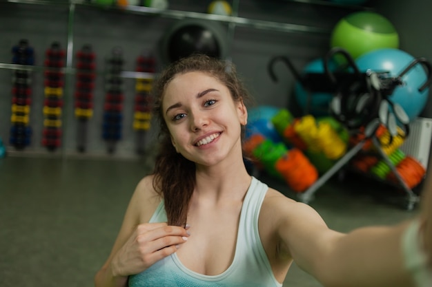 Mujer joven alegre en forma hace selfie en clase de deportes