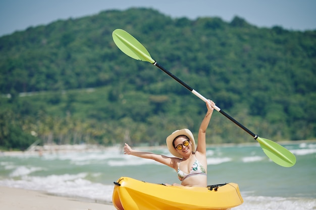 Mujer joven alegre en kayak boa