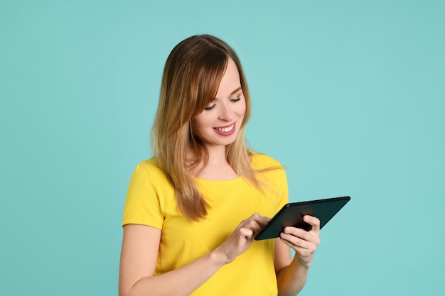 Mujer joven alegre que usa la tableta