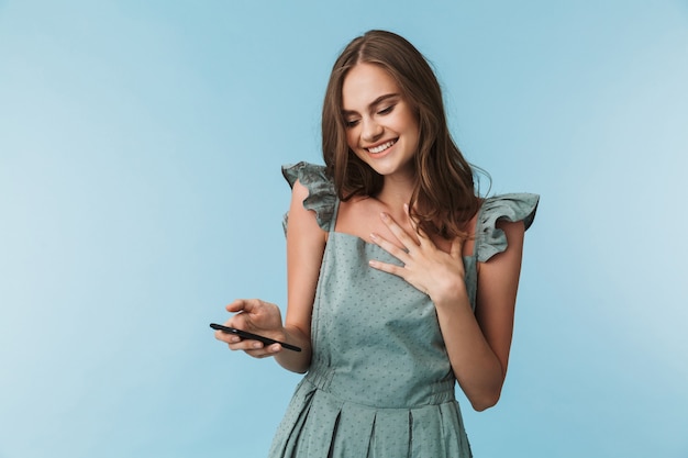 Mujer joven alegre mediante teléfono móvil.