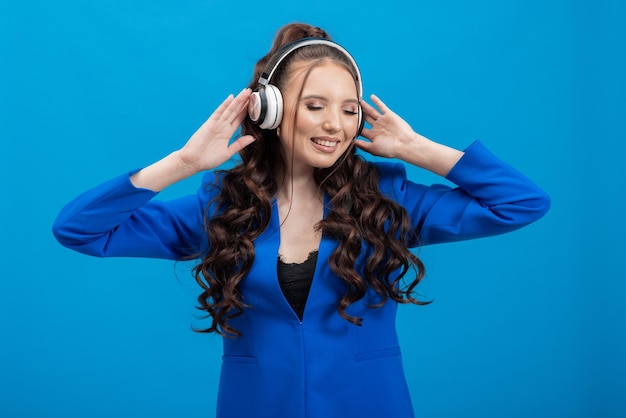 Mujer joven alegremente usando auriculares escuchando música sonriendo con los ojos cerrados