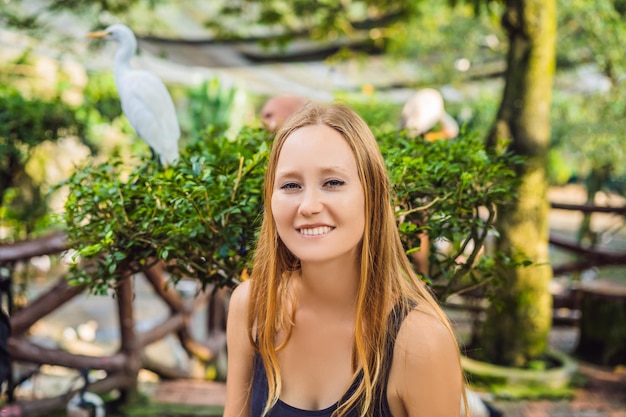 Mujer joven alimentando ibes en el parque Garceta común Garcilla bueyera Bubulcus ibis Waters Edge