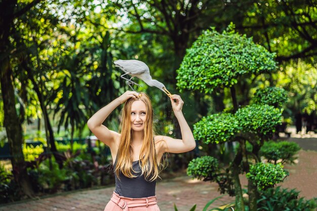 Mujer joven alimentando ibes en el parque Garceta común Garcilla bueyera Bubulcus ibis Waters Edge