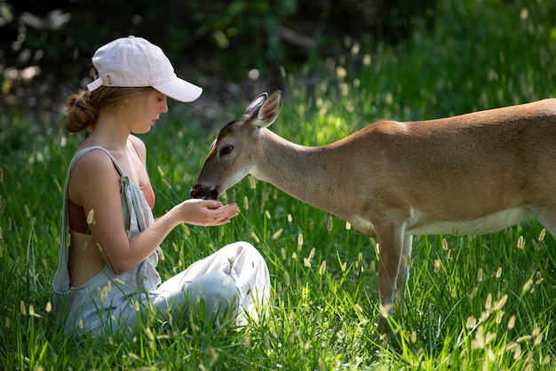 Mujer joven alimentar ciervos bambi lindo concepto de animales salvajes