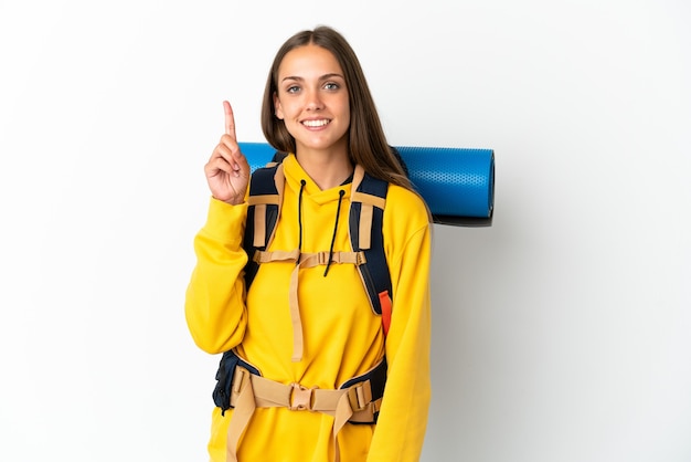 Mujer joven alpinista con una gran mochila sobre fondo blanco aislado apuntando hacia una gran idea