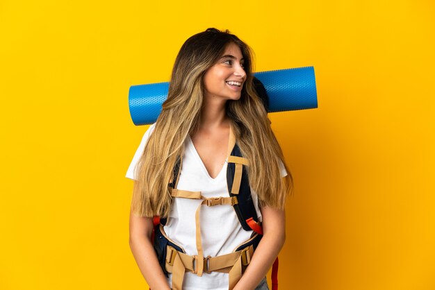 Mujer joven alpinista con una mochila grande aislada