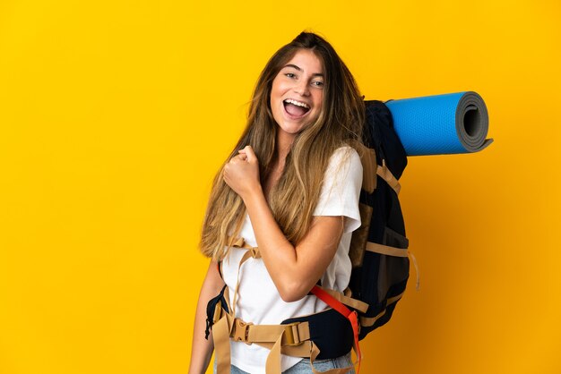 Mujer joven alpinista con una mochila grande aislada