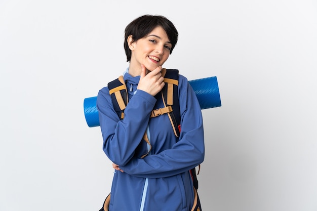 Mujer joven alpinista sobre pared aislada feliz y sonriente