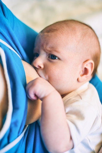 Mujer joven amamantando a su pequeño bebé infantil en casa