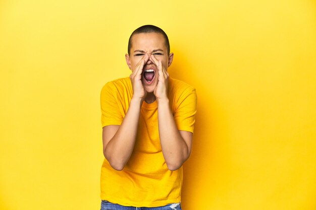 mujer joven, en, amarillo, tee, amarillo, estudio, fondo, gritos, emocionado, a, frente