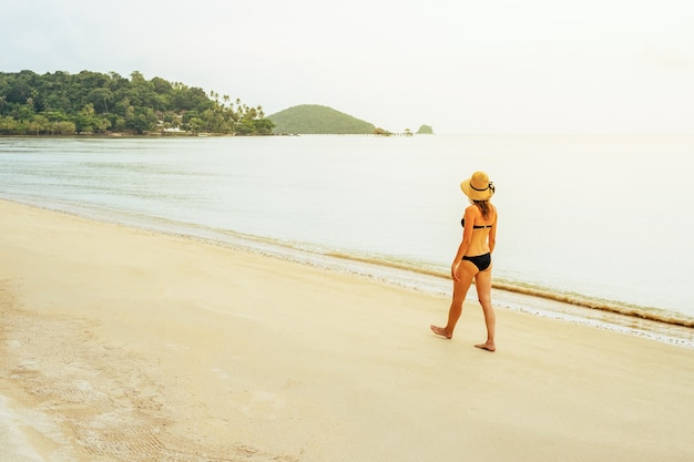 Mujer joven, ambulante, en, playa, debajo, ocaso