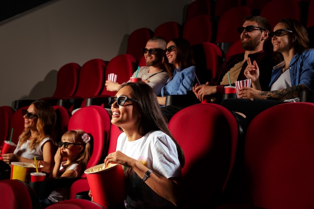 Mujer joven con amigos viendo una película en el cine