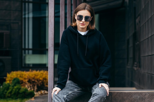 mujer joven, en, anteojos, y, negro, hoodie