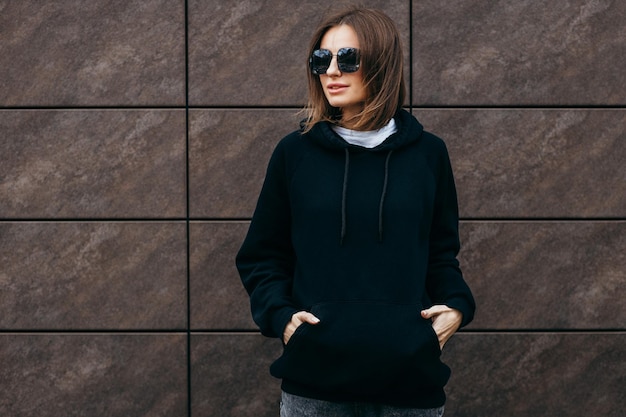 mujer joven, en, anteojos, y, negro, hoodie