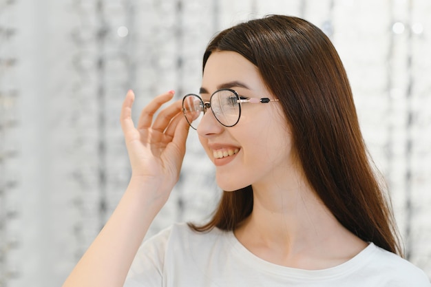 mujer joven, con, anteojos, en, óptico, tienda