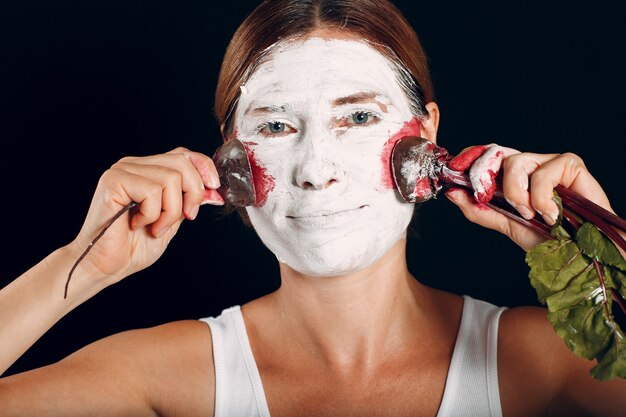 Mujer joven aplicando maquillaje, pinta la cara con remolacha y maquillaje. Cómo no hacer el concepto de maquillaje.