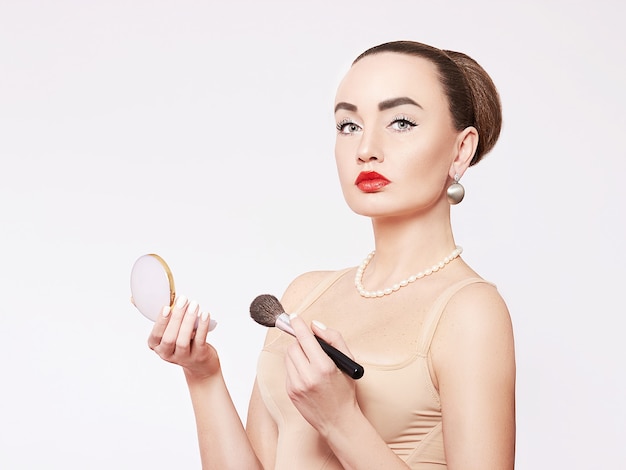 Una mujer joven aplicando maquillaje.