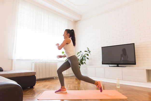 Mujer joven apta ejercicio en la habitación