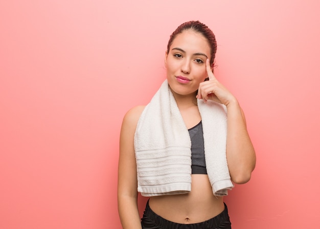 Mujer joven de la aptitud que piensa en una idea