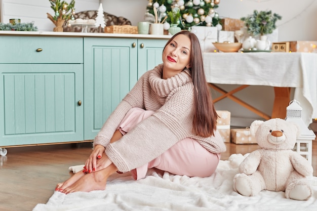 Mujer joven con árbol de navidad