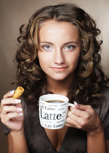 Mujer joven con un aromático café en manos