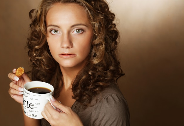 Mujer joven con un aromático café en manos