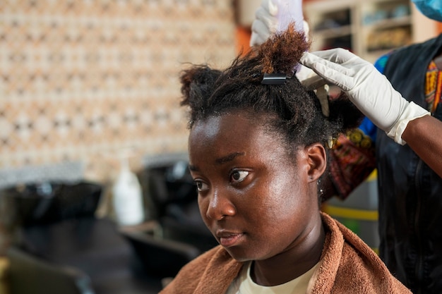 Mujer joven arreglando su cabello en el salón