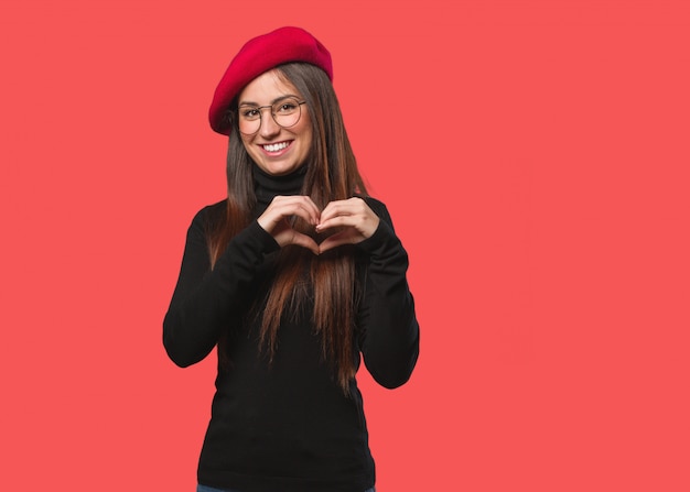 Mujer joven artista haciendo forma de corazón con manos